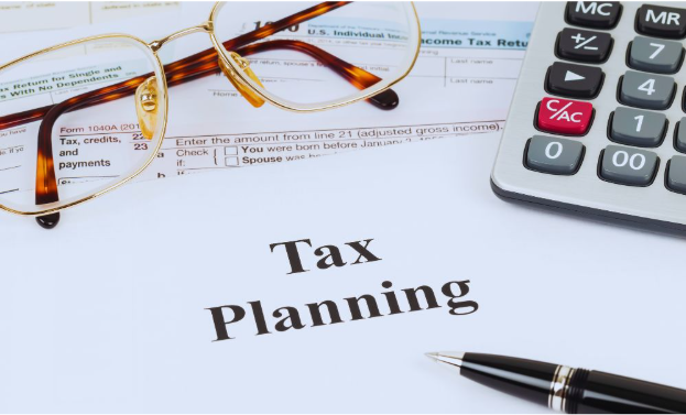 A desk setup with a document titled "Tax Planning," IRS forms, calculator, and pen, representing customized tax plans for business owners.